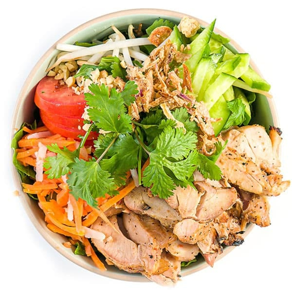 Vietnamese grilled chicken salad with fresh vegetables, herbs, and crispy fried onions in a bowl.